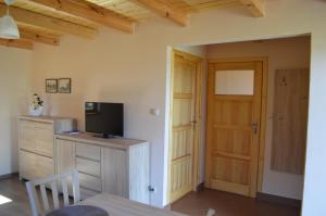 a room with a tv on a dresser and a door at Domki letniskowe PLUSK in Drawno +17 photos
