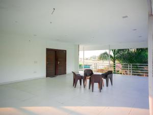 a room with three chairs and a table in it at Rosewood farms in Noida