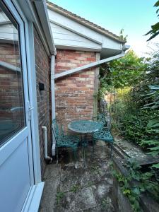 a patio with two chairs and a table next to a building at Beejou in Sedlescombe +9 photos
