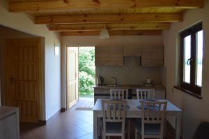 a kitchen with a table and chairs in a room at Domki letniskowe PLUSK in Drawno