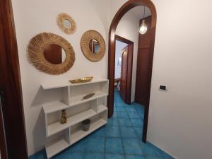 a hallway with two mirrors on the wall and a shelf at Mirtillo by Amalfivacation in Minori