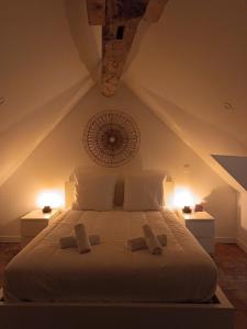 a bedroom with a white bed with two towels on it at Le logis de Diane in Candé-sur-Beuvron
