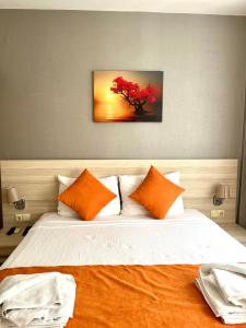 a bedroom with a large bed with orange pillows at Limon Pansiyon in Foça +25 photos