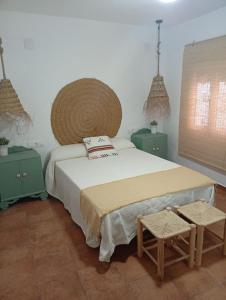a bedroom with a large bed and two tables at Casa Rural la Sierra del Viento in Guadalcanal