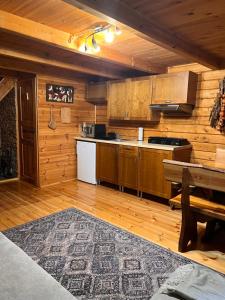 a kitchen with wooden cabinets and a table in a cabin at Hello Kurpie in Nowogród
