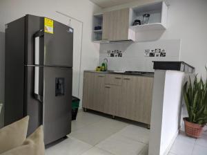 a kitchen with a stainless steel refrigerator and cabinets at Mami yola 2 in Valledupar