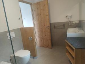 a bathroom with a toilet and a sink at Mitterhofer Appartements in Villandro