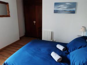 a blue bed with two pairs of socks on it at La grange aux oiseaux in Beaulieu