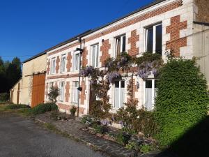 a brick building with flowers on the side of it at La grange aux oiseaux in Beaulieu