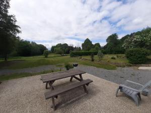a picnic table and a bench in a park at La grange aux oiseaux in Beaulieu +4 photos