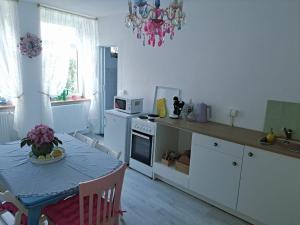 a kitchen with a table and a kitchen with a chandelier at Apartment MICHAELA in Spital am Pyhrn