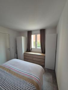 LecciにあるLes hameaux de Saint Cyprien - appartement avec jardin et piscineのベッドと窓のある小さな寝室