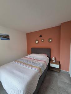a bedroom with a bed and two clocks on the wall at Appartement climatisé avec jardin et piscine in Lecci +8 photos
