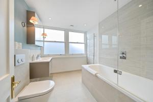 un bagno con vasca, WC e lavandino di Ping Pong Flat a Londra Altre 18 foto