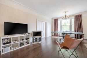 un soggiorno con TV, tavolo e TV di Ping Pong Flat a Londra