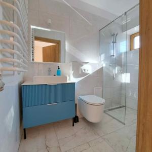 Un baño con lavabo, inodoro y espejo. en Niwy8Rooms, en Oświęcim