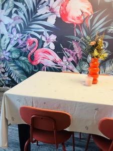 a white table with a vase of flowers on it at ViMaJU in Koper