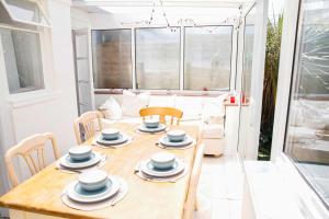a dining room table with plates and bowls on it at Brighton & Hove, 4 bedrooms, 5 beds, Garage in Brighton & Hove +16 photos