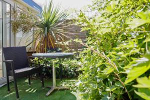 a patio with a table and a chair and plants at Brighton & Hove, 4 bedrooms, 5 beds, Garage in Brighton & Hove