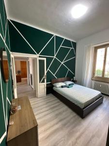 a bedroom with a bed and a green wall at VSuite Linate in Milan
