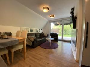 a living room with a couch and a table at Holiday home Seehütte in Kleinsaubernitz