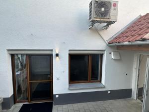 a white house with a window and a air conditioner at FeWo Riegel - Allgäu nah an A7 & Legoland in Illertissen