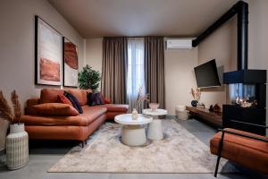 a living room with a couch and a tv at Reve Suites Ioannina in Ioannina