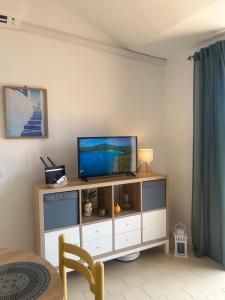 a living room with a television on a cabinet at Bella Vista La Bussola in Scalea