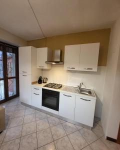 een keuken met witte kasten en een kookplaat oven bij La Terrazza Panoramica in San Sebastiano