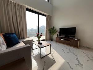 a living room with a couch and a flat screen tv at 3BR Duplex Near Cleveland & Galleria Mall in Abu Dhabi