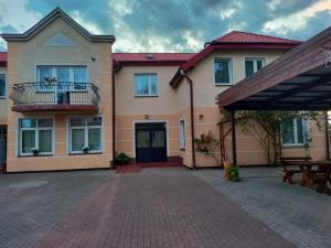 a large house with a patio and a building at Jaśmin -pokoje gościnne in Ustka