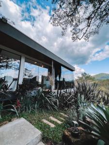 a house with glass windows and plants in front of it at Cabana QUARTZO- Vista para PONTO TURISTIC0 Pedra Morro do Campestre- ACESSO até a cabana asfaltado in Urubici