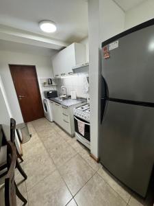 a small kitchen with a refrigerator and a stove at Ushuaienses in Ushuaia