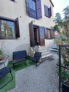un groupe de chaises assis à l'extérieur d'un bâtiment dans l'établissement Gîte 4 étoiles, centre Monein, 4 chambres, terrasse, jusqu'à 8 pers, à Monein