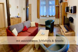 a living room with a couch and a table at Ferienwohnung Auszeit am Kurpark Bad Berka # Balkon # ruhige Lage # gratis Parkplatz & WLAN # Weimarer Land # nahe Weimar & Erfurt in Bad Berka