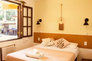 a bedroom with a bed with towels on it at Calmaria Suítes Búzios in Búzios