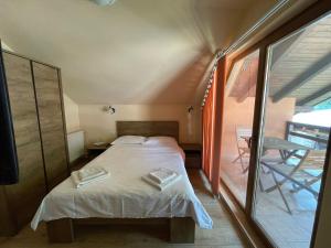 a small bedroom with a bed and a balcony at Casa Bianca in Băile Herculane