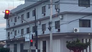 a red traffic light in front of a white building at IPE Palace Hotel in Corumbá