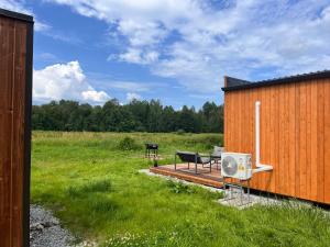 a building with a deck with a bench and a grill at Napu Puhkemaja in Rabivere