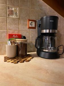 a coffee maker on a counter next to a pile of cookies at Cosy Nest Apartment in the Heart of Samos in Samos