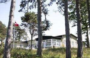 a house in the woods with a canadian flag at Gilbjerg Strandhotel in Gilleleje