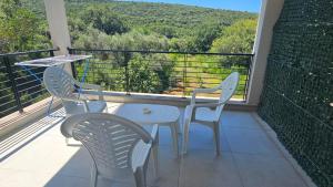 two chairs and a table on a balcony with a view at Aqua Apartments in Bigova +8 photos