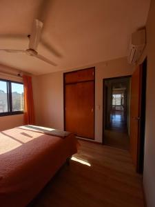 a bedroom with a bed and a door to a hallway at CuyenCo in Santa Rosa de Calamuchita