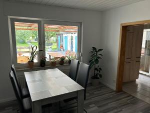 a dining room with a table and chairs and a window at Ferienwohnung am Waldrand mit großem Garten in Leverkusen