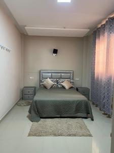 阿加迪尔Superbe appartement en centre ville的一间卧室，墙上有一张床和一台电视