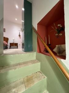 een trap in een huis met een groene deur bij Maison Remì in Castellana Grotte