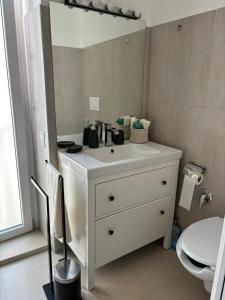 een badkamer met een witte wastafel en een spiegel bij Maison Remì in Castellana Grotte