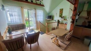 a living room with a table and chairs and a kitchen at Tawerna Murena in Poddąbie