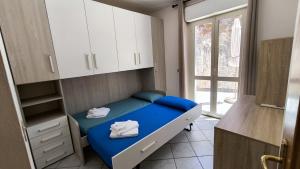 a room with a bed with blue sheets and white cabinets at Il Fortino Residence - Three-room apartment La Maddalena in La Maddalena