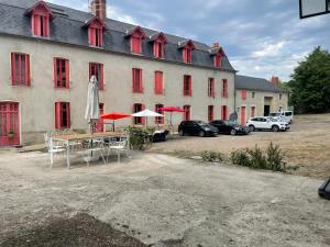 a large building with tables and umbrellas in front of it at Grande maison avec piscine privée à Garchizy sur 650 m² in Garchizy